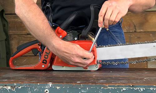 A man precisely operates a chainsaw to cut wood