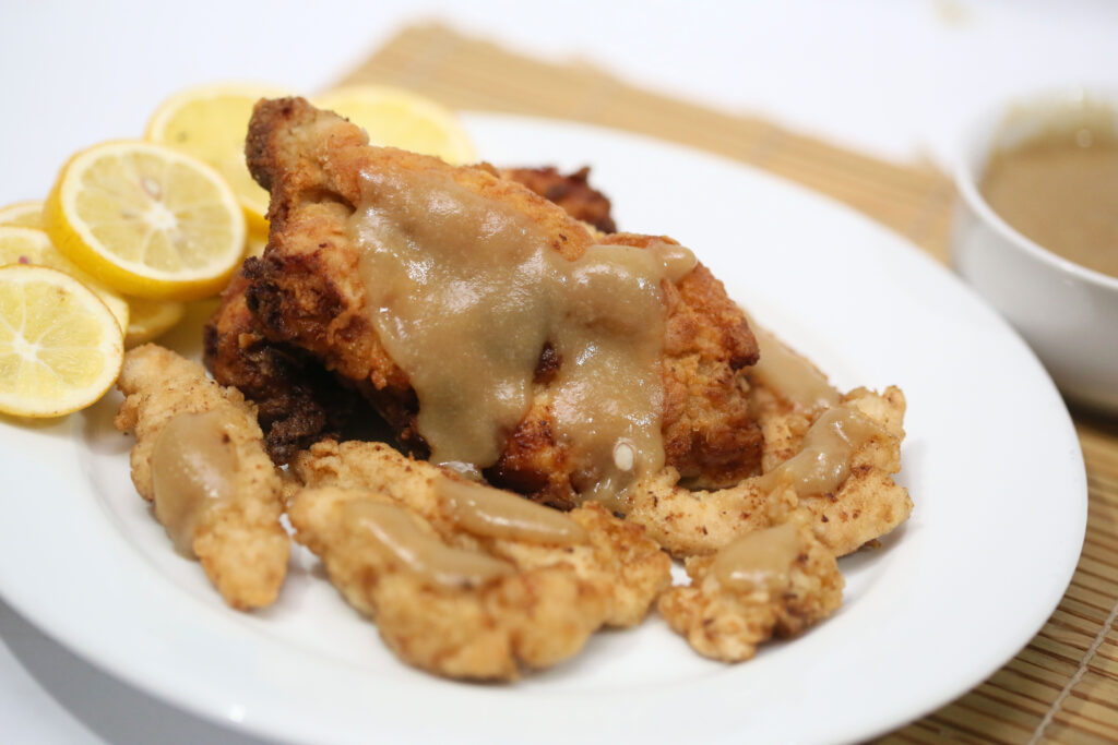 Fried chicken with savory gravy and tangy lemon wedges, a delectable dish from China's renowned chicken food brands