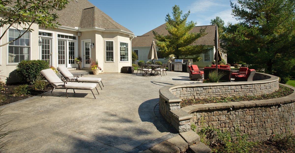 Concrete patio with stone wall and seating area