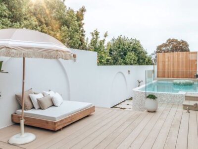 A serene backyard featuring a pool and a white deck