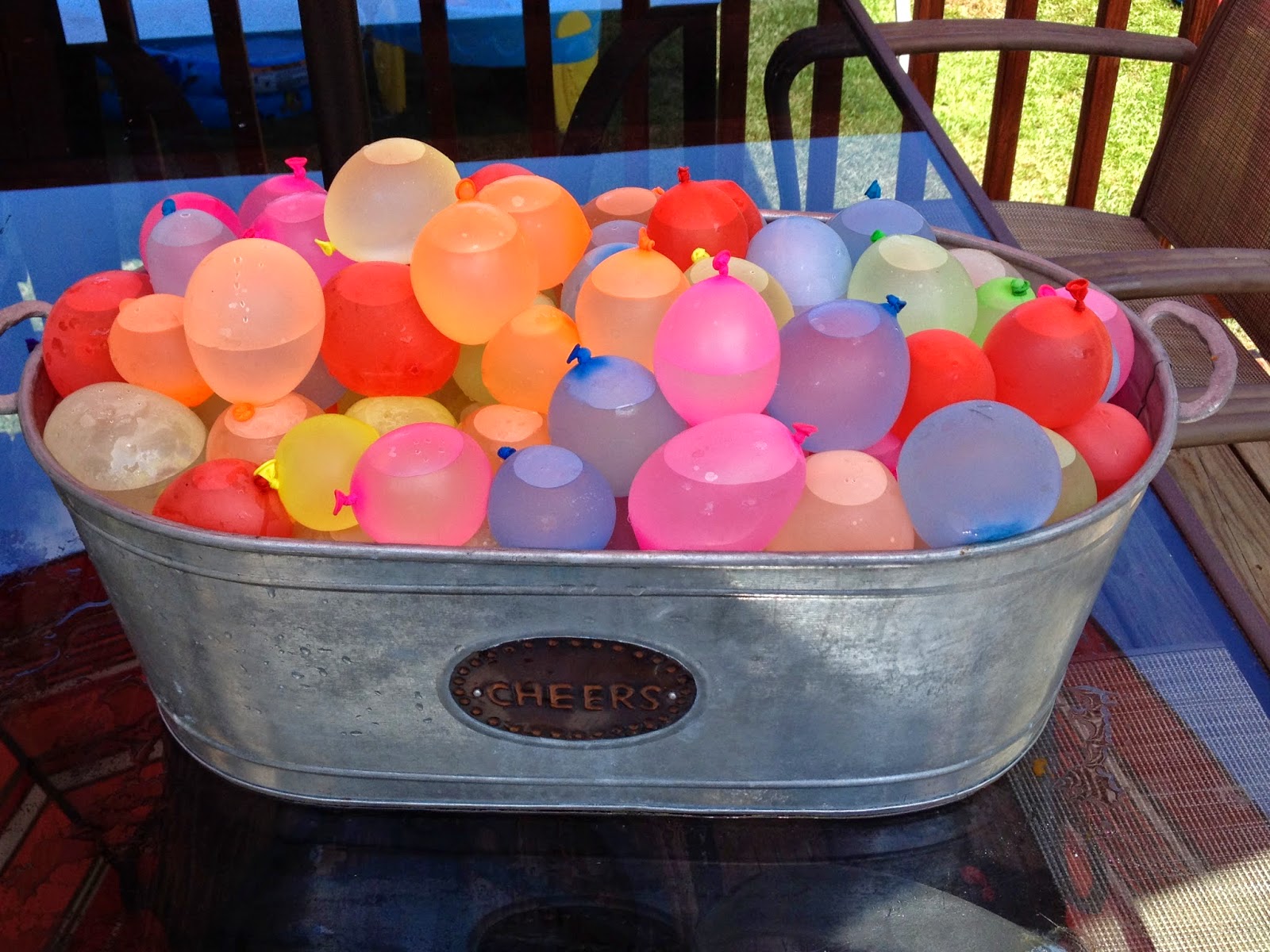 A bucket filled with colorful balloons sitting on a table.