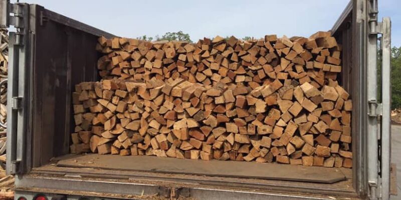 A truck full of logs being loaded.