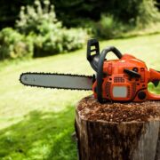 A chainsaw resting on a stump, ready for use