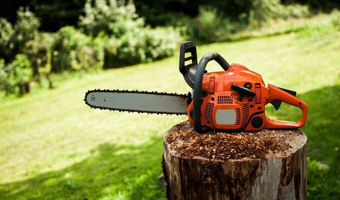 A chainsaw resting on a stump, ready for use