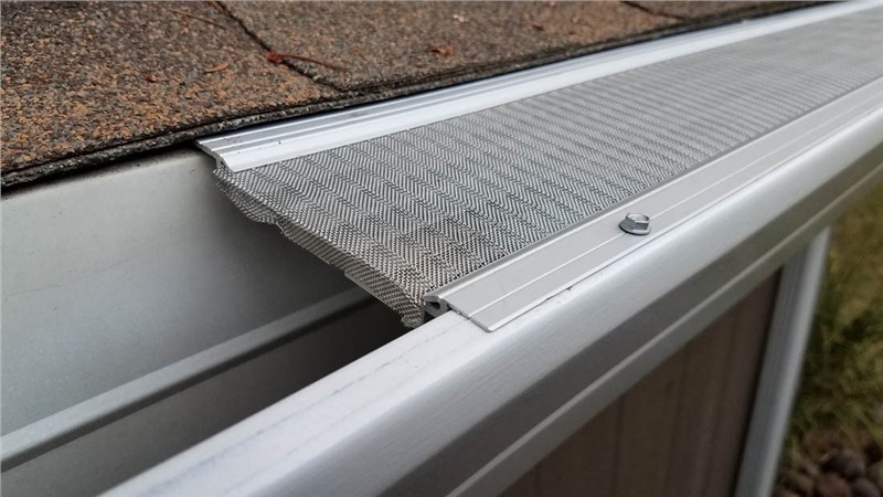 A close-up of a gutter with a metal screen