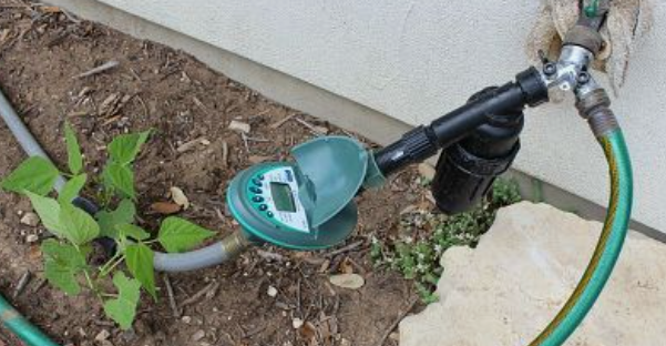 A garden hose connected to a garden timer, emphasizing the importance of paying attention