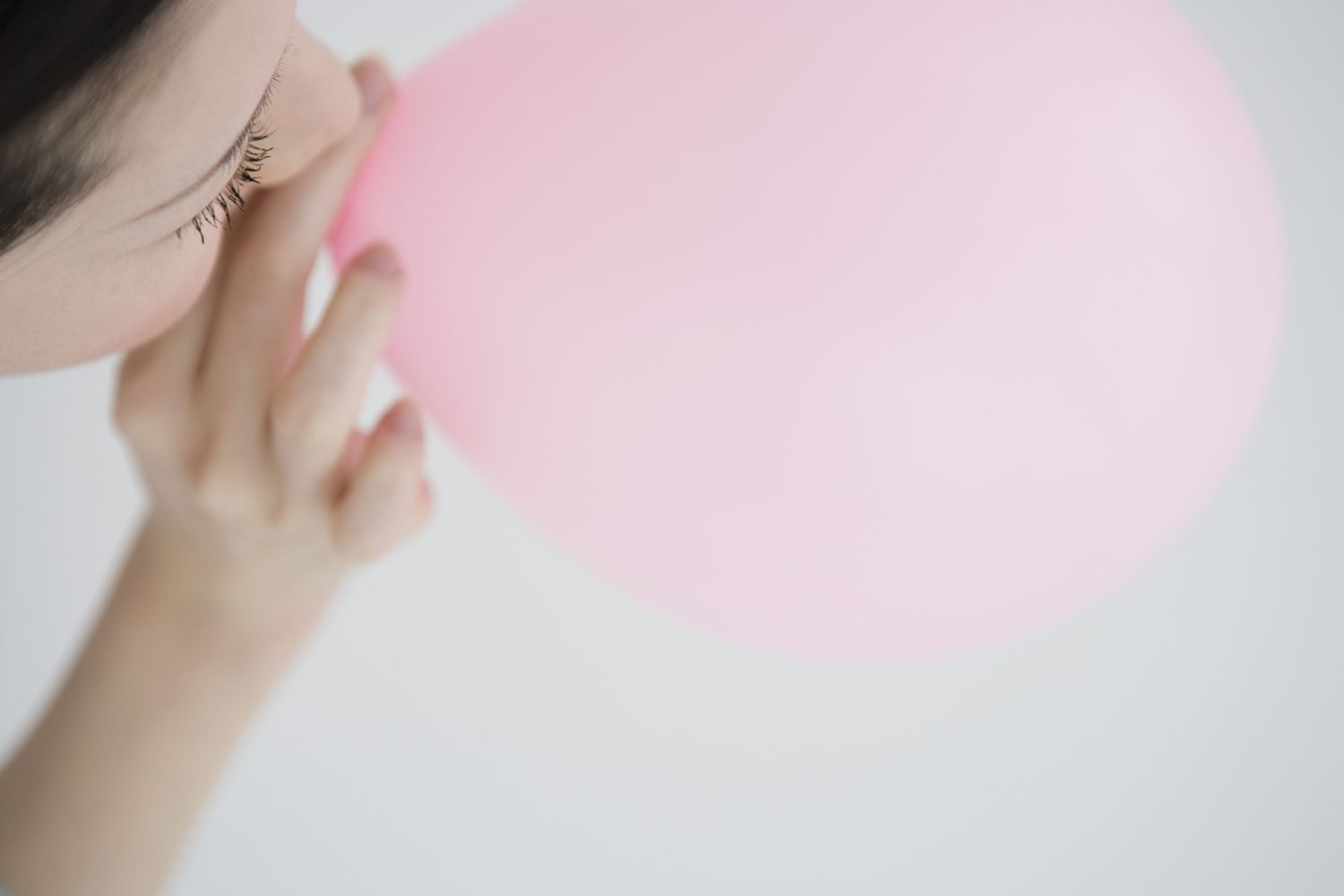 A person inhaling helium from a balloon
