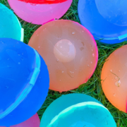 Colorful plastic balls on grass, a fun alternative to water balloons for outdoor activities