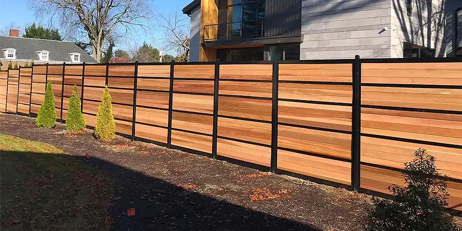 A custom-designed fence made of wood and metal panels, showcasing professional materials