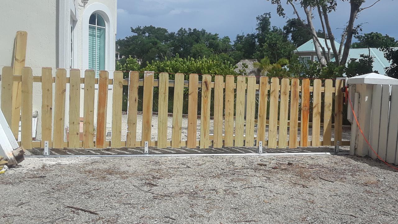 A wooden fence being constructed in front of a house, providing privacy and enhancing the property's appearance. Less Stress